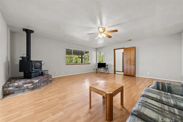 a view of an empty room with a window and a kitchen