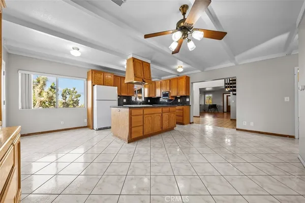 a kitchen with stainless steel appliances granite countertop a stove cabinets and living room view