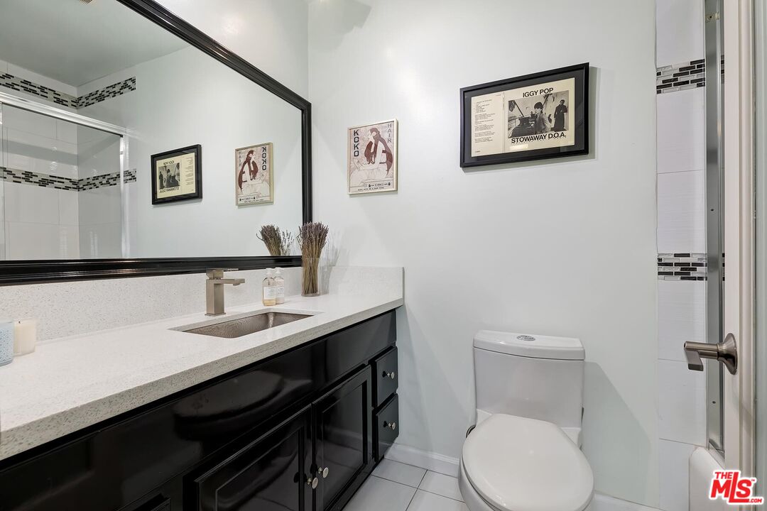 1045 North Kings Road, Unit 310 West Hollywood, CA 90069 - Photo 12 of 14 a bathroom with a toilet a sink and mirror