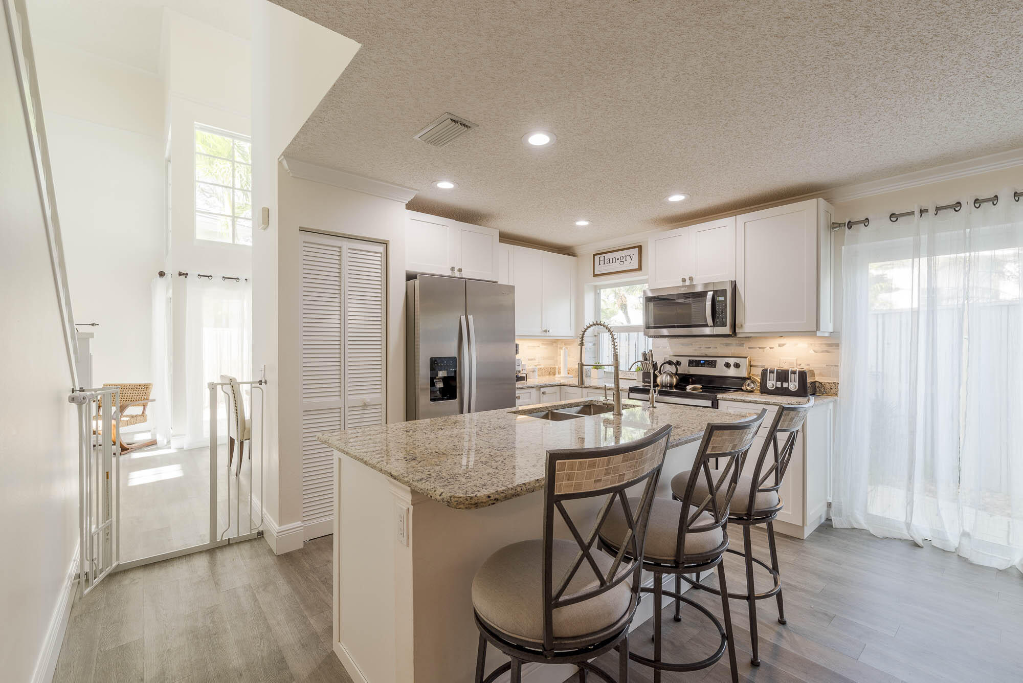 25 Commodore Place Palm Beach Gardens, FL 33418 - Photo 11 of 68 a kitchen with stainless steel appliances a dining table chairs refrigerator and microwave