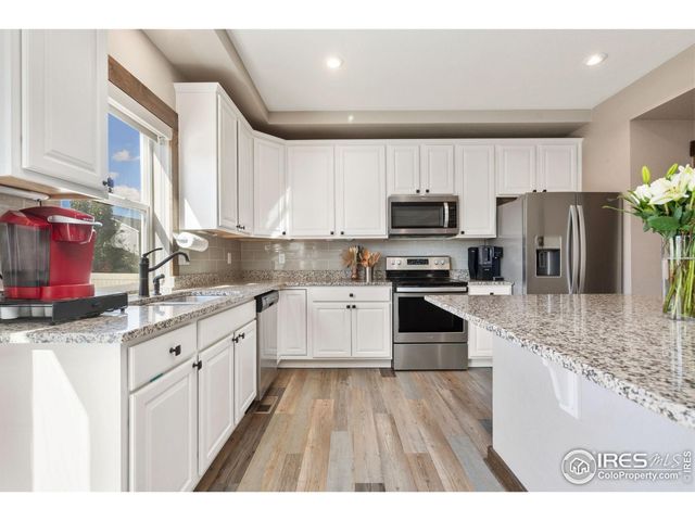 a kitchen with granite countertop a refrigerator stove and sink