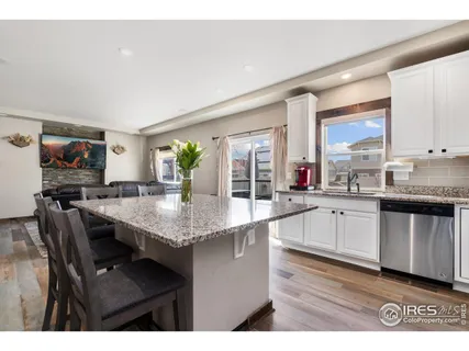 a kitchen with granite countertop a sink cabinets and wooden floor