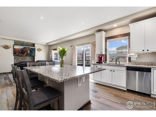 a kitchen with granite countertop a sink cabinets and wooden floor