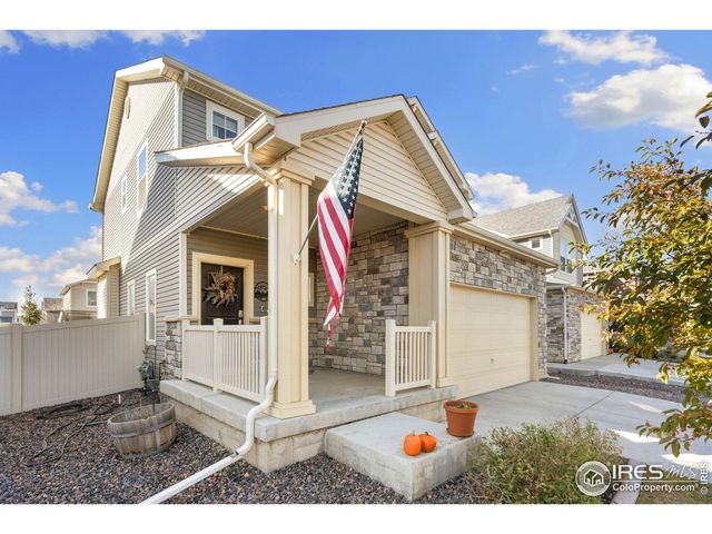 a view of a white house with a small yard and potted plants