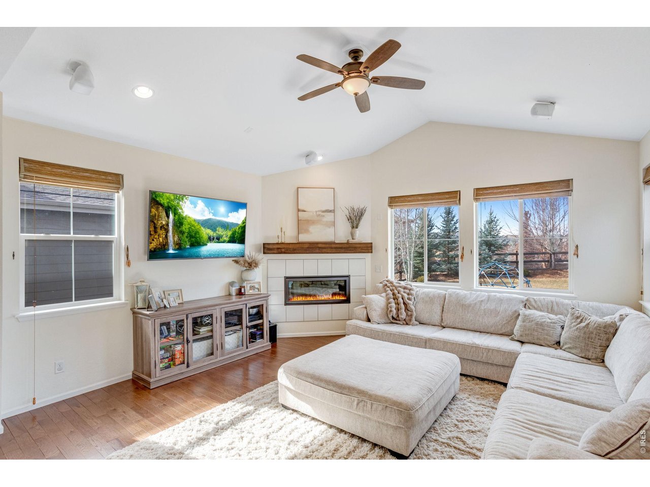 12715 Eagle River Road Firestone, CO 80504 - Photo 7 of 28 Inviting living room featuring a gas fireplace, large windows, and comfortable gathering space.