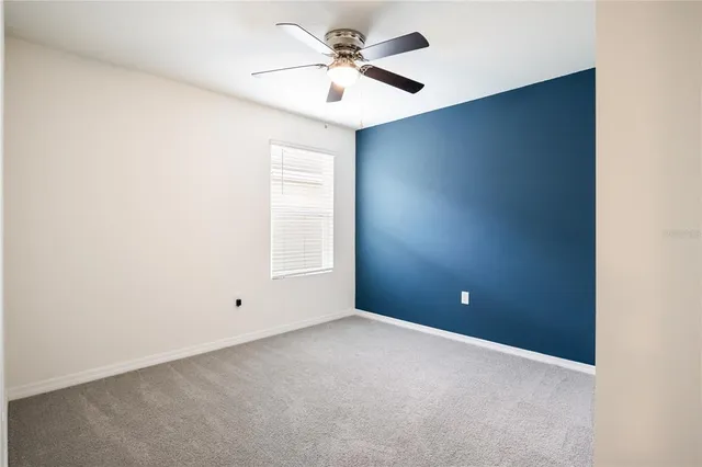 an empty room with closet and a ceiling fan