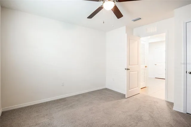 an empty room with closet and windows