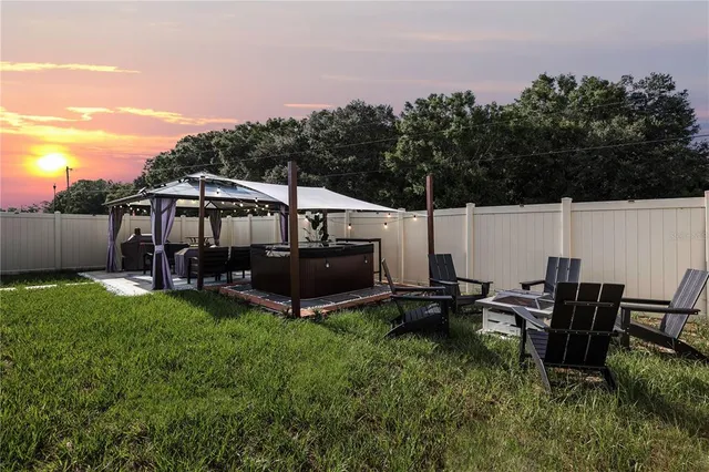 a view of a patio with table and chairs a barbeque grill with wooden fence