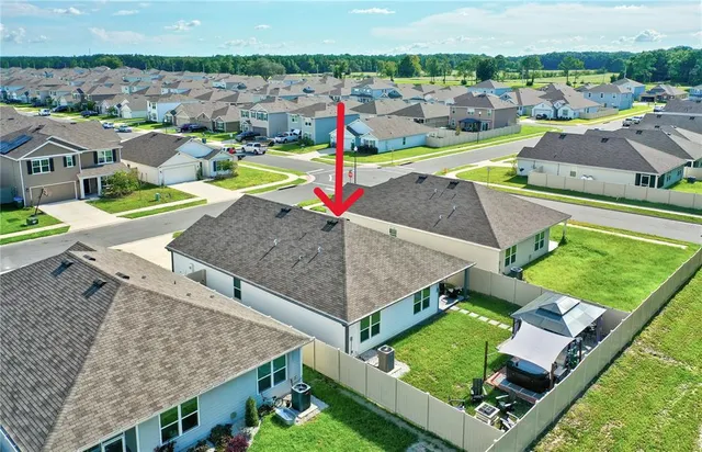 an aerial view of a house with a swimming pool a patio and yard