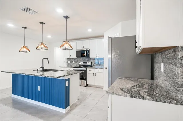 a kitchen with kitchen island a sink stainless steel appliances and cabinets