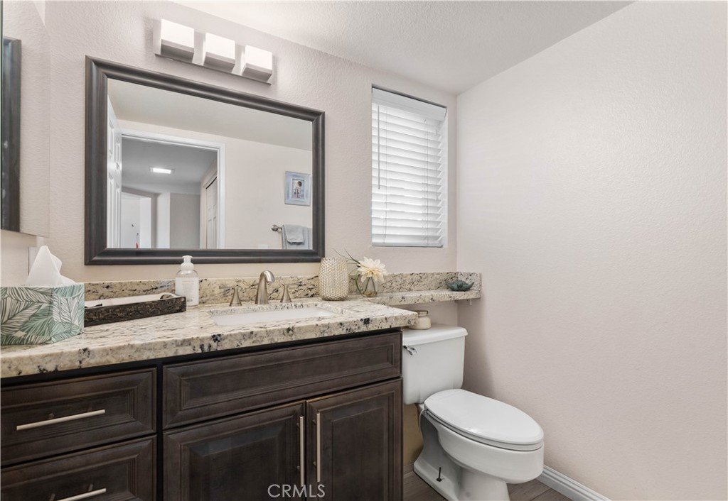 10963 San Mateo Place Rancho Cucamonga, CA 91701 - Photo 19 of 37 a bathroom with a granite countertop toilet sink and mirror