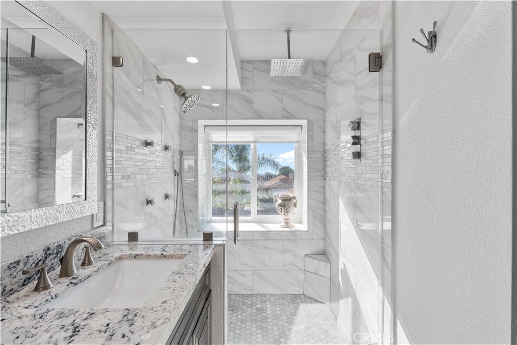 10963 San Mateo Place Rancho Cucamonga, CA 91701 - Photo 25 of 37 a bathroom with a granite countertop sink a mirror and a shower