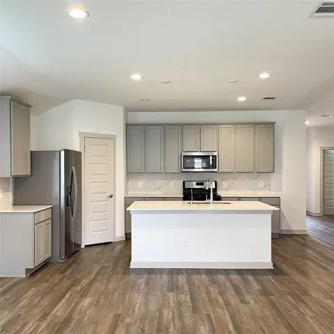 a kitchen with stainless steel appliances a refrigerator and a stove top oven