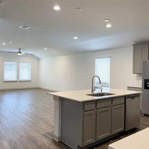 a kitchen with a sink cabinets and wooden floor