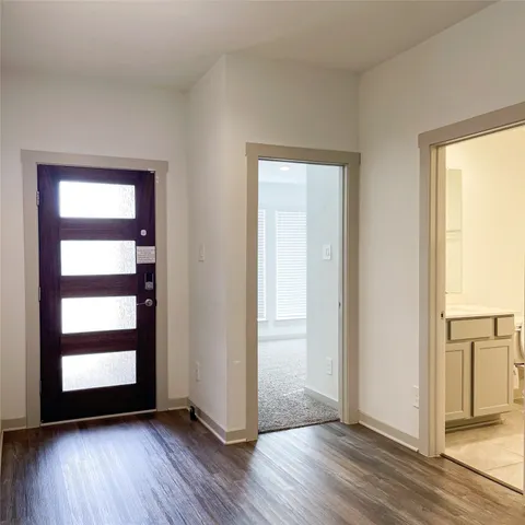 a view of empty room with wooden floor and window