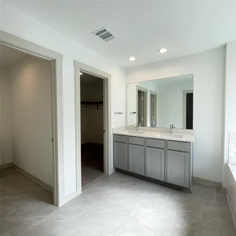 a bathroom with a double vanity sink and mirror