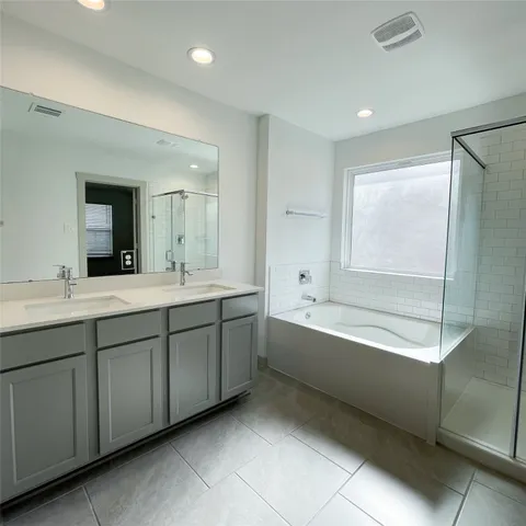 a spacious bathroom with a tub sink shower and mirror