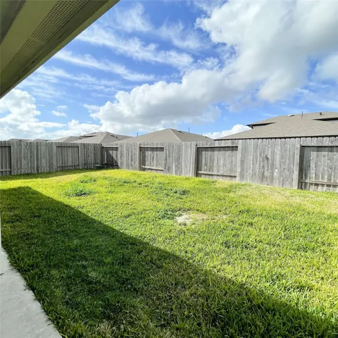 a view of a house with a yard and a large tree
