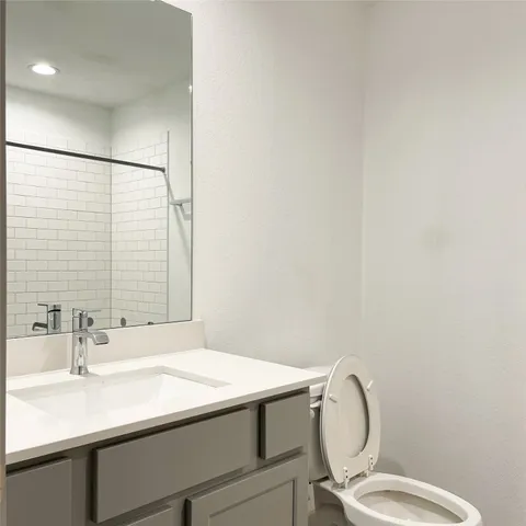 a bathroom with a sink a toilet and mirror