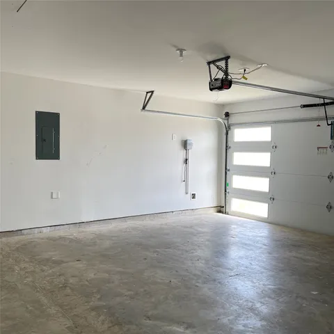 an empty room with wooden floor ceiling fan and windows