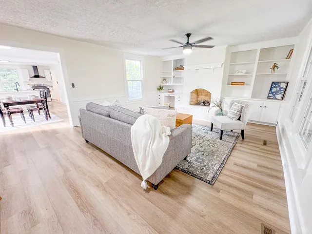 a living room with furniture and a wooden floor