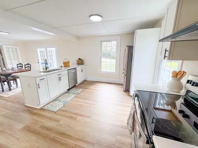 a large white kitchen with cabinets