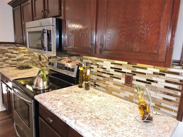 a kitchen with stainless steel appliances wooden cabinets and a stove top oven
