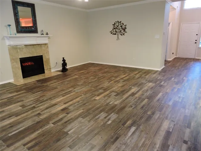 a view of empty room with wooden floor and fireplace
