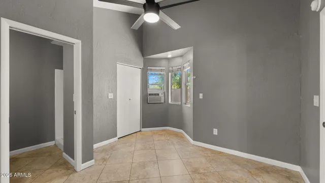 an empty room with closet and a chandelier fan