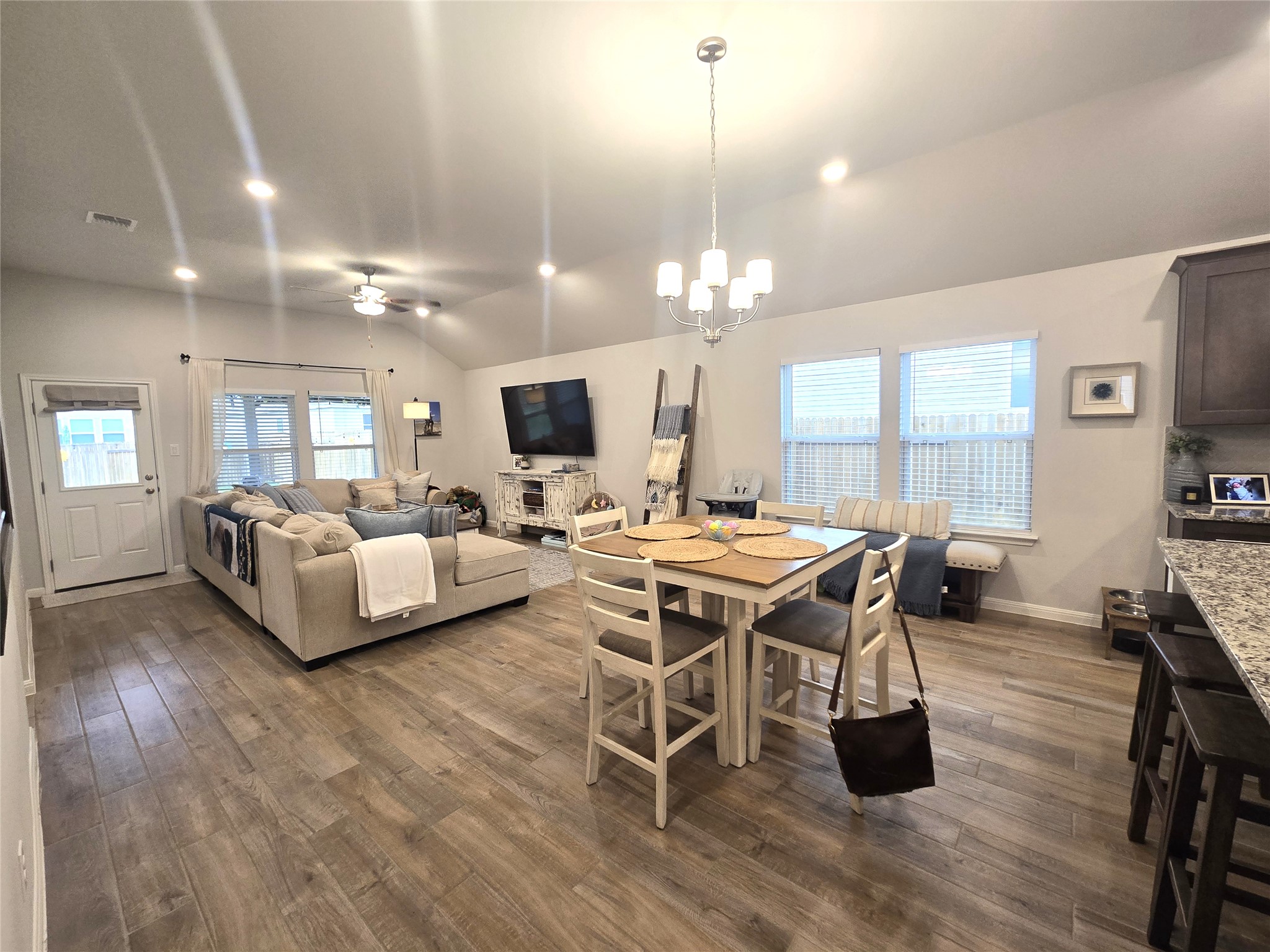 133 Boulder Ridge Trail Liberty Hill, TX 78642 - Photo 10 of 32 Dining area with ceiling fan, dark wood-type flooring, vaulted ceiling, and a chandelier