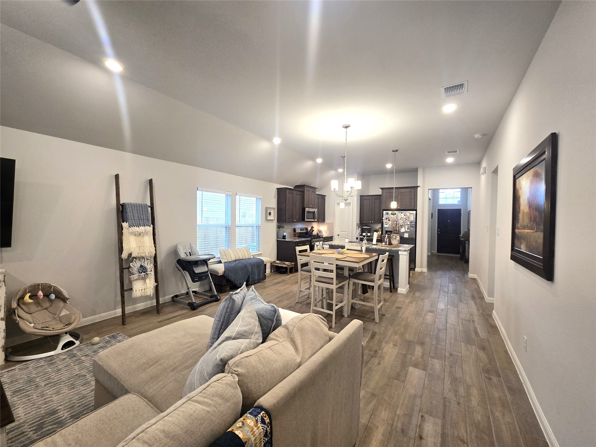 133 Boulder Ridge Trail Liberty Hill, TX 78642 - Photo 12 of 32 Living area featuring dark wood-type flooring, hanging lights, and lofted ceiling
