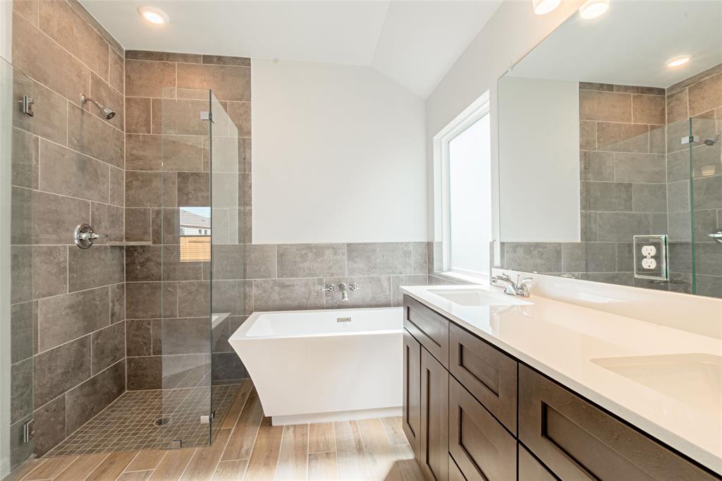 133 Boulder Ridge Trail Liberty Hill, TX 78642 - Photo 17 of 32 Bathroom featuring a freestanding bath, a shower stall, tile walls, double vanity, and lofted ceiling