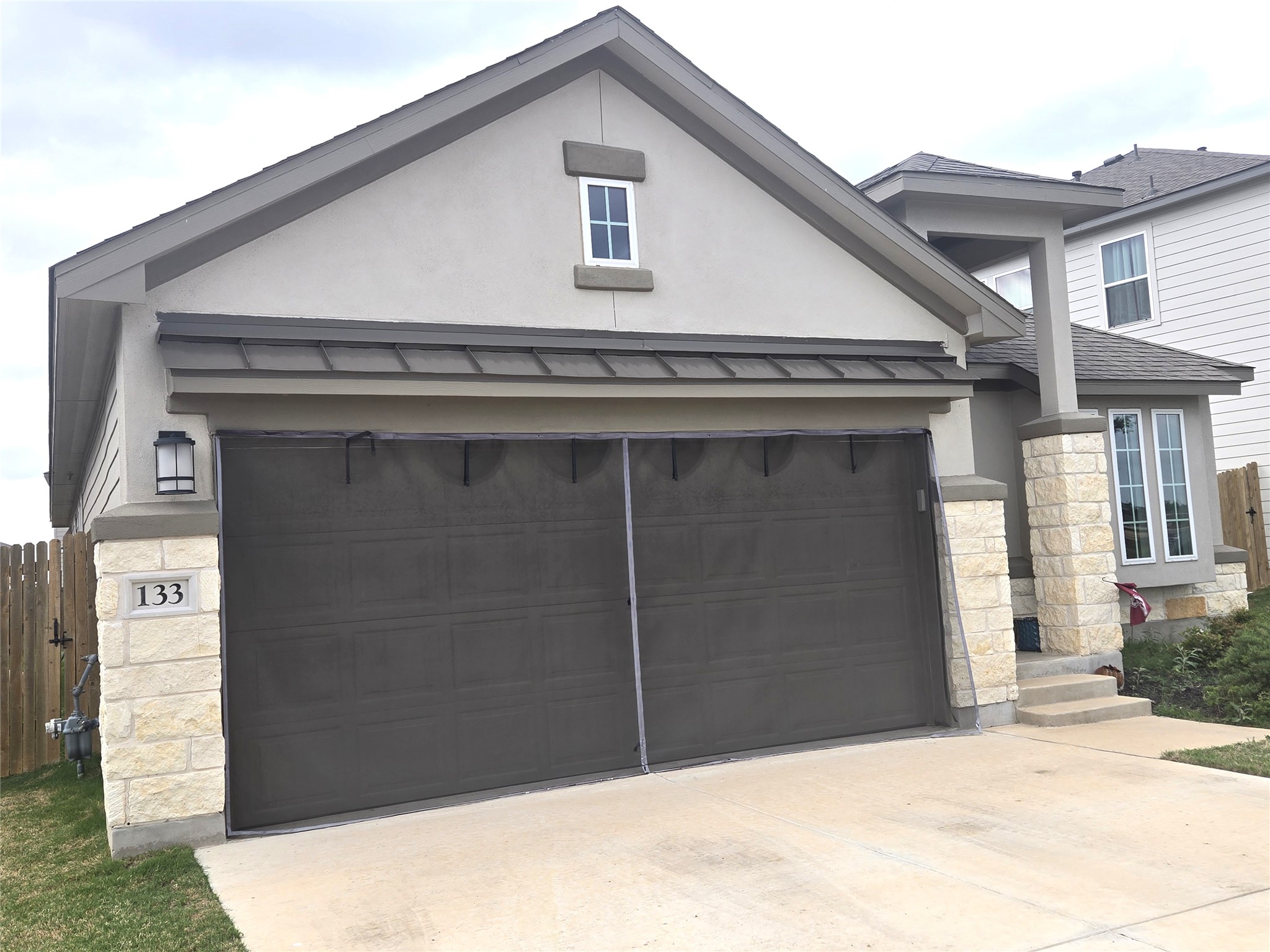 133 Boulder Ridge Trail Liberty Hill, TX 78642 - Photo 2 of 32 View of front of house with stone siding, stucco siding, concrete driveway, an attached garage, and a standing seam roof