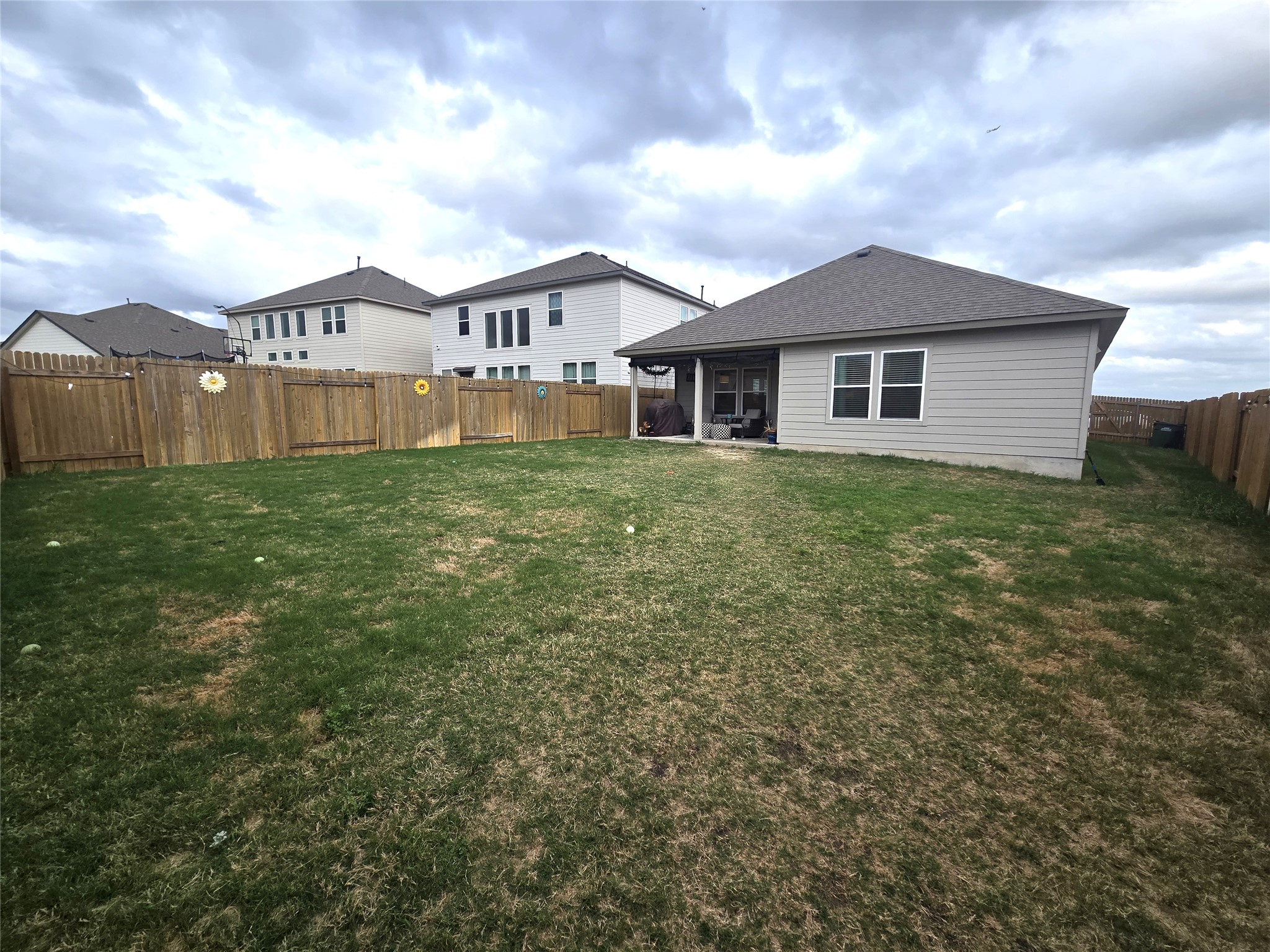 133 Boulder Ridge Trail Liberty Hill, TX 78642 - Photo 27 of 32 Rear view of property featuring a fenced backyard, roof with shingles, and a sunroom