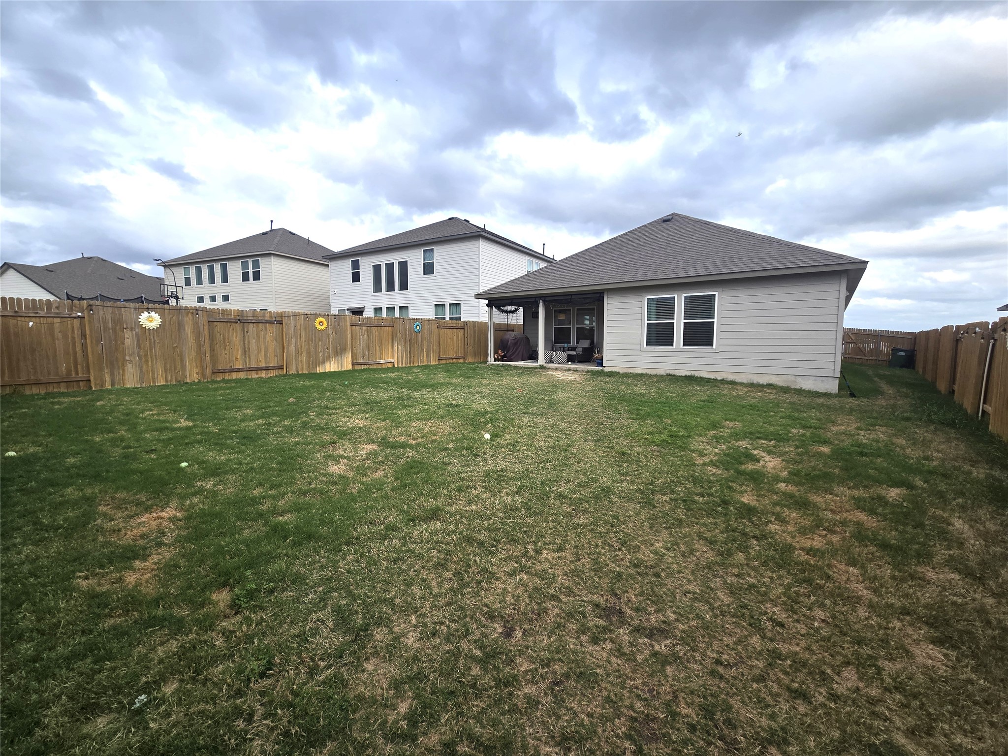133 Boulder Ridge Trail Liberty Hill, TX 78642 - Photo 28 of 32 Rear view of house with a fenced backyard, a sunroom, and roof with shingles
