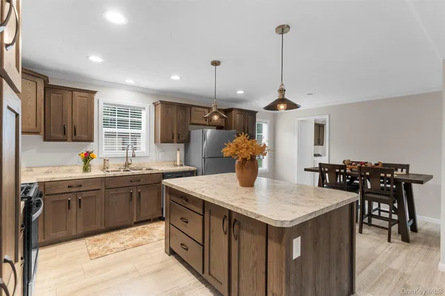 a kitchen with granite countertop a sink a counter space appliances and cabinets