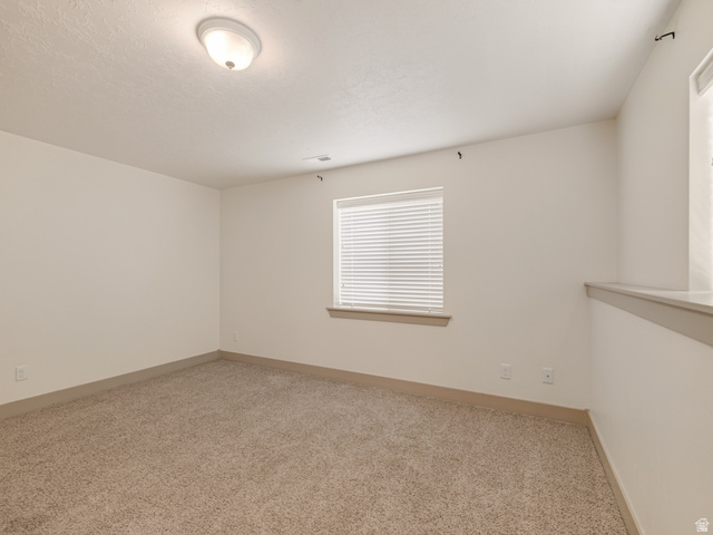 1279 West 1500th Street North Mapleton, UT 84664 - Photo 60 of 83 Spacious room featuring neutral carpeting, a large window with horizontal blinds, and a semi-flush ceiling light fixture