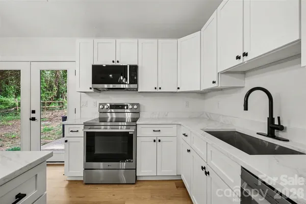 a kitchen with stainless steel appliances granite countertop a stove a sink and a microwave