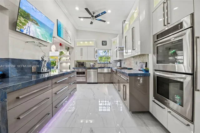 a large kitchen with stainless steel appliances granite countertop a stove a sink and a refrigerator