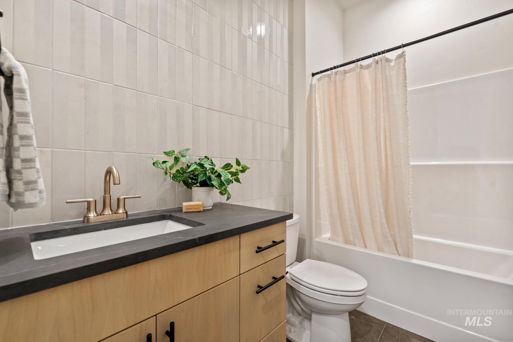2866 North Stone Mill Avenue, Unit ROUGE Eagle, ID 83616 - Photo 11 of 18 Bathroom with vanity, shower / tub combo, tile walls, and dark tile patterned flooring