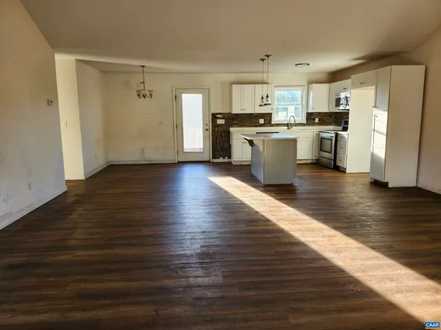 a view of kitchen with wooden floor and electronic appliances