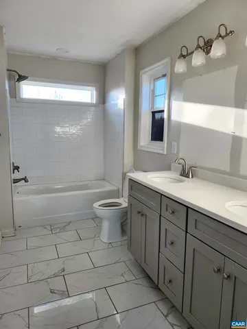 a bathroom with a double vanity sink a toilet and a mirror