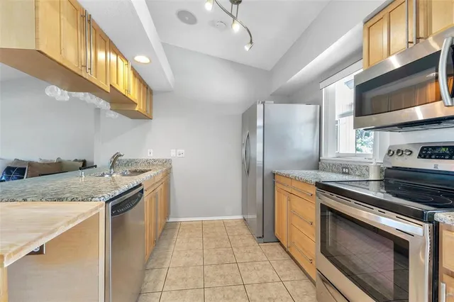 a kitchen with granite countertop a stove and a sink