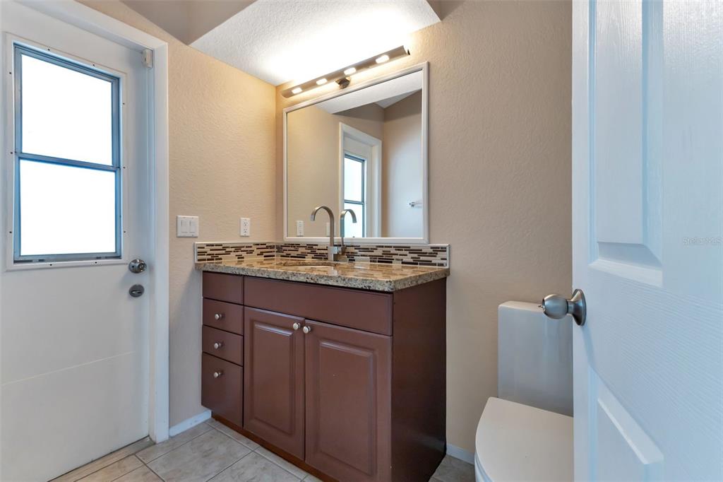 23177 Rye Avenue Punta Gorda, FL 33980 - Photo 22 of 48 a bathroom with a granite countertop sink toilet and mirror