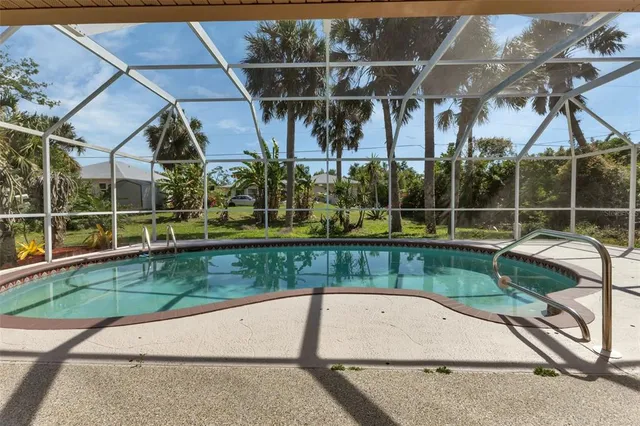 a view of a swimming pool with a patio and a yard