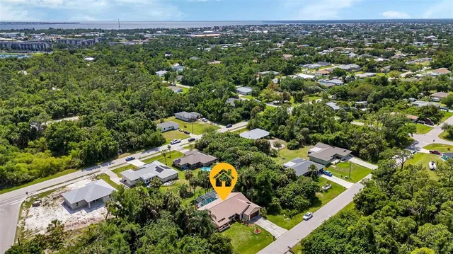 an aerial view of residential houses with outdoor space and trees