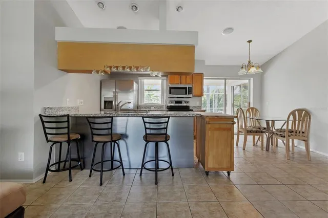 a kitchen with stainless steel appliances granite countertop a table and chairs in it