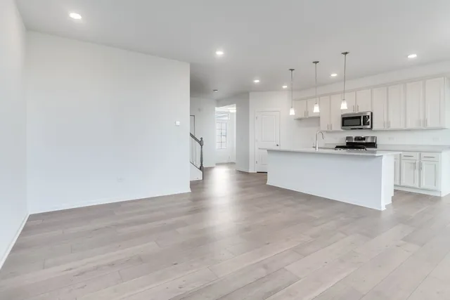 a view of kitchen with granite countertop stainless steel appliances refrigerator sink and cabinets