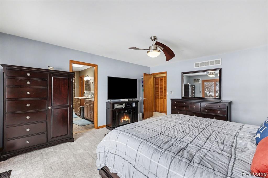 7277 Cardinal Road Algonac, MI 48001 - Photo 26 of 36 Bedroom with ceiling fan, light colored carpet, and ensuite bath
