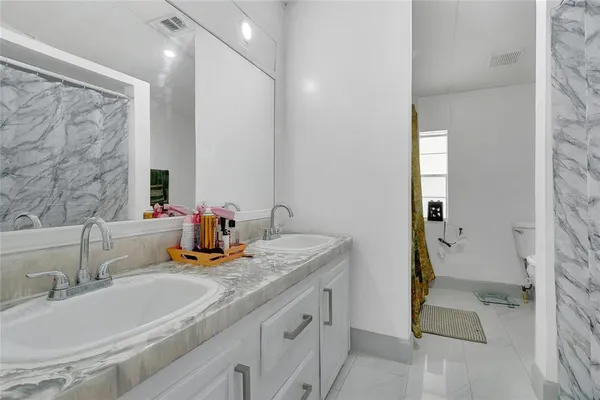 a bathroom with a granite countertop sink and a mirror